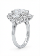 Diamond ring with pear-shaped and round diamonds on a white background