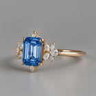 Gold ring with a blue gemstone and smaller diamonds on a gray background
