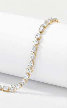 Gold bracelet with diamonds in different cuts on a white background