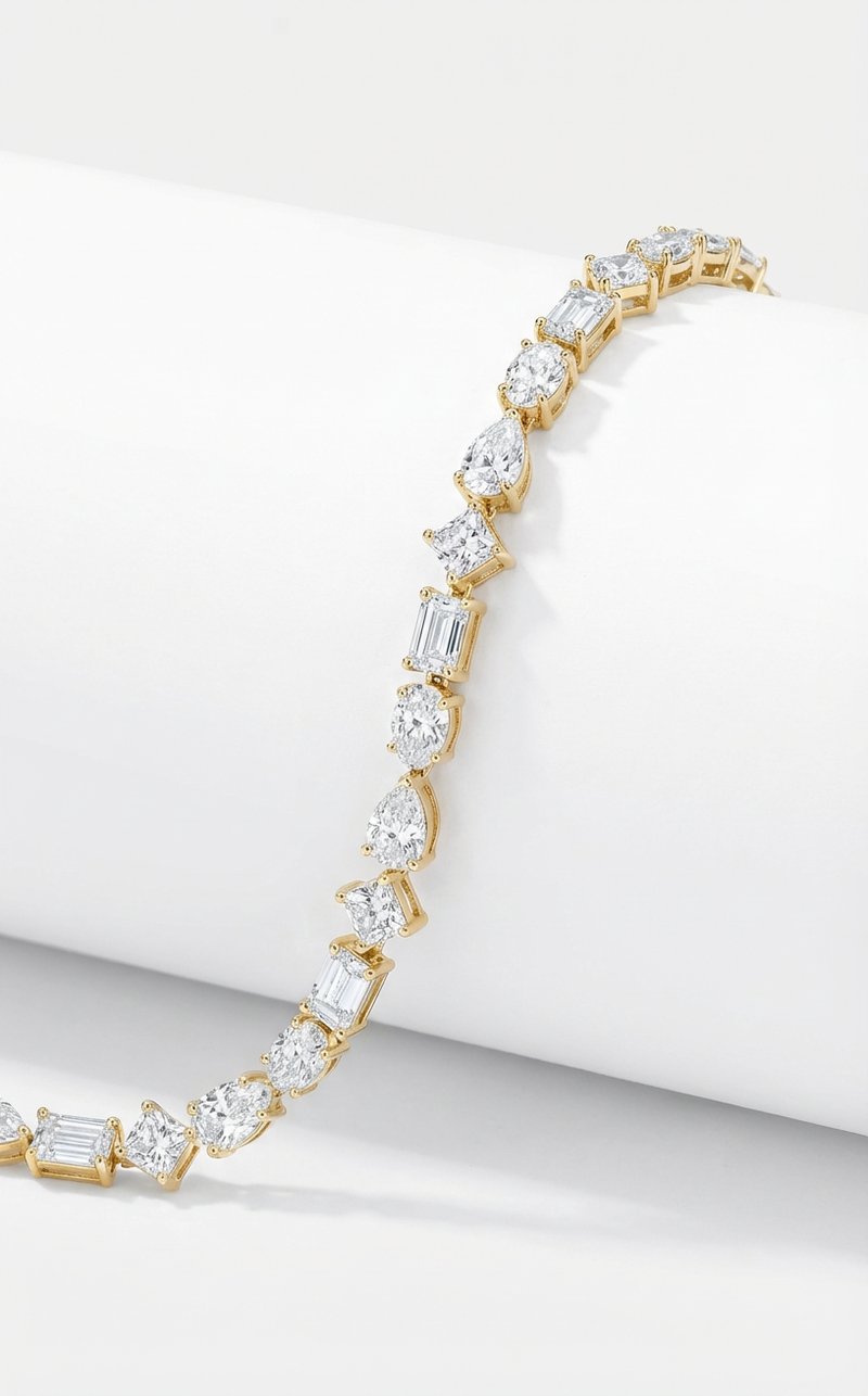 Gold bracelet with diamonds in different cuts on a white background