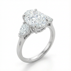 Diamond ring with an oval center stone and two smaller stones on a white background