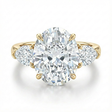 Gold ring with a large diamond and smaller diamonds on the sides against a white background