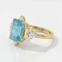 Gold ring with a blue gemstone and diamond accents on a white background