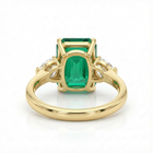 Gold ring with a green gemstone on a white background