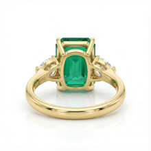 Gold ring with a green gemstone on a white background