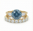 Gold ring with a blue gemstone and smaller diamonds on a white background