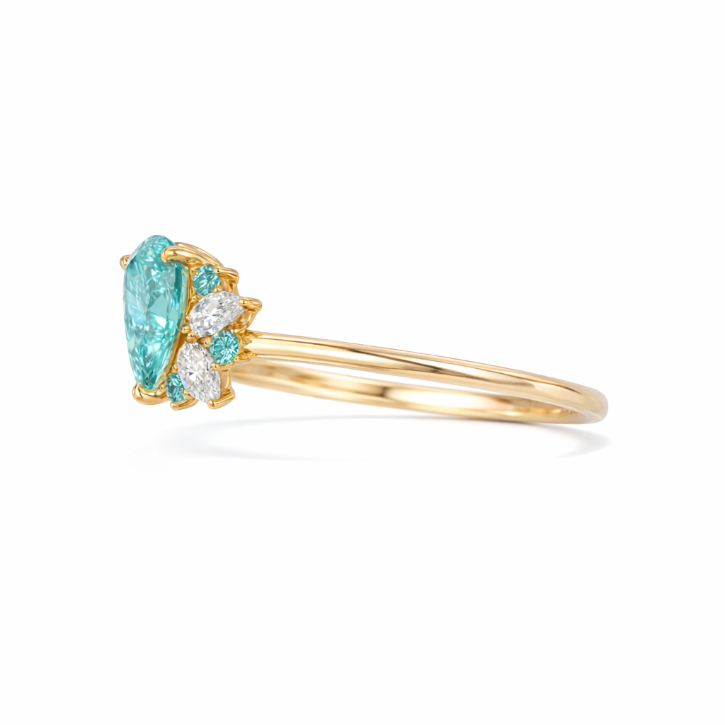 Gold ring with a pear-shaped blue gemstone and smaller diamonds on a white background