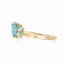 Gold ring with a pear-shaped blue gemstone and smaller diamonds on a white background