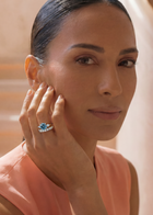 Woman wearing a blue diamond ring with a soft background