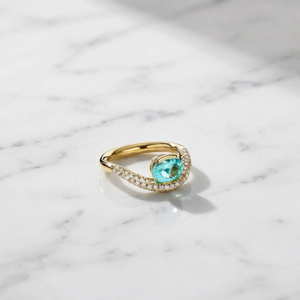 Gold ring with a green gemstone on a marble surface