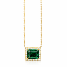 Gold necklace with a green gemstone pendant on a white background