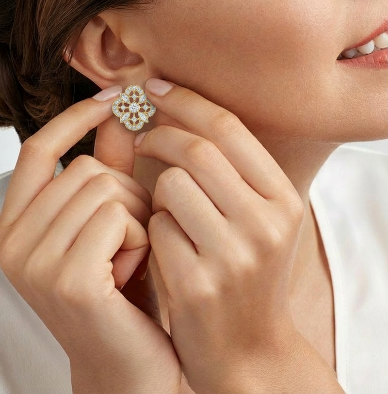 Close-up of a person holding a diamond earring near their ear.