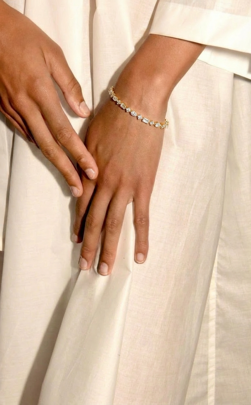 Two hands holding each other with a mix cut diamond bracelet on a white background