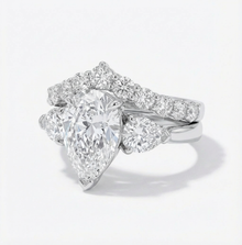 Diamond ring with a pear-shaped center stone on a white background
