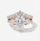 Rose gold diamond ring with pear-shaped center stone on a white background