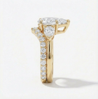 Gold ring with diamond accents on a light gray background