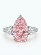 A pear-cut pink diamond ring with a silver-toned band accented by two round diamonds, set against a clean white background.