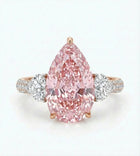 Pink diamond ring with rose gold and white gold band on a light gray background
