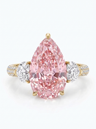 A pear-cut pink diamond ring set in yellow gold with two round diamonds on the band, photographed on a clean white background.