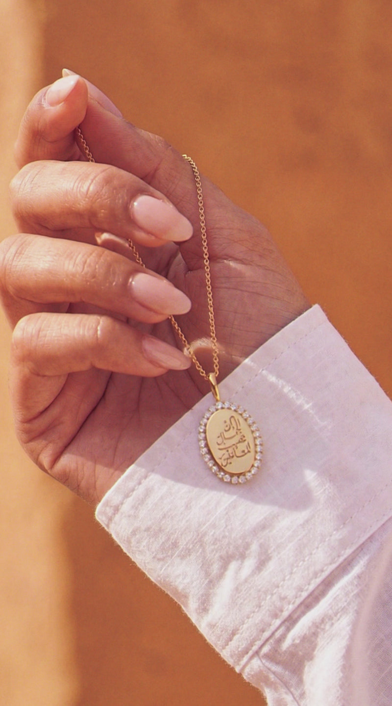 halo signature oval pendant with lab made diamonds being shown by a model in Arabian setting 