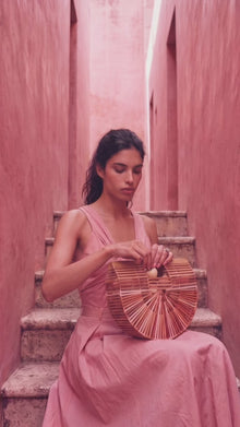 video of model wearing a pink diamond ring and eating strawberries and carrying a fashionable straw handbag 