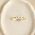 Gold ring with a diamond on a beige background