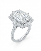 Diamond ring with a prominent radient-cut center stone on a white background