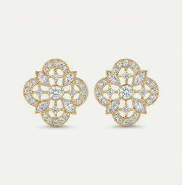 Gold and diamond earrings on a light beige background