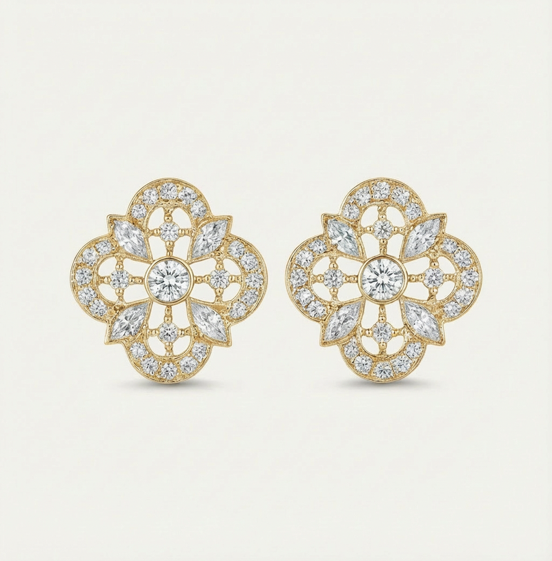 Gold and diamond earrings on a light beige background