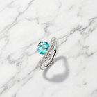 Silver ring with a blue gemstone on a marble background