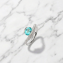 Silver ring with a blue gemstone on a marble background