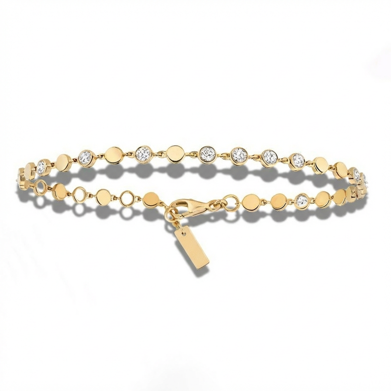 Gold bracelet with small round beads and a tag on a white background