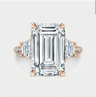 Diamond ring with emerald-cut center stone and rose gold accents on a light gray background