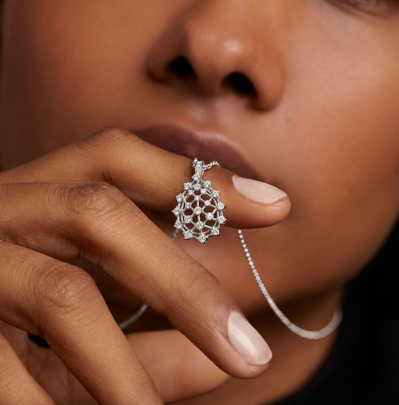 Close-up of a person wearing a silver necklace with a detailed pendant.