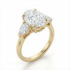 Gold ring with a large central diamond and two smaller diamonds on a white background