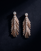 Pair of rose gold and crystal earrings on a dark background
