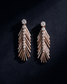 Pair of rose gold and crystal earrings on a dark background