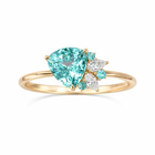 Gold ring with a large blu gemstone and smaller diamonds on a white background green 