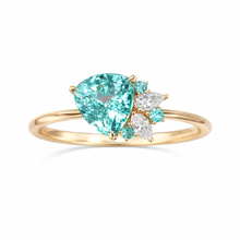 Gold ring with a large blu gemstone and smaller diamonds on a white background green 