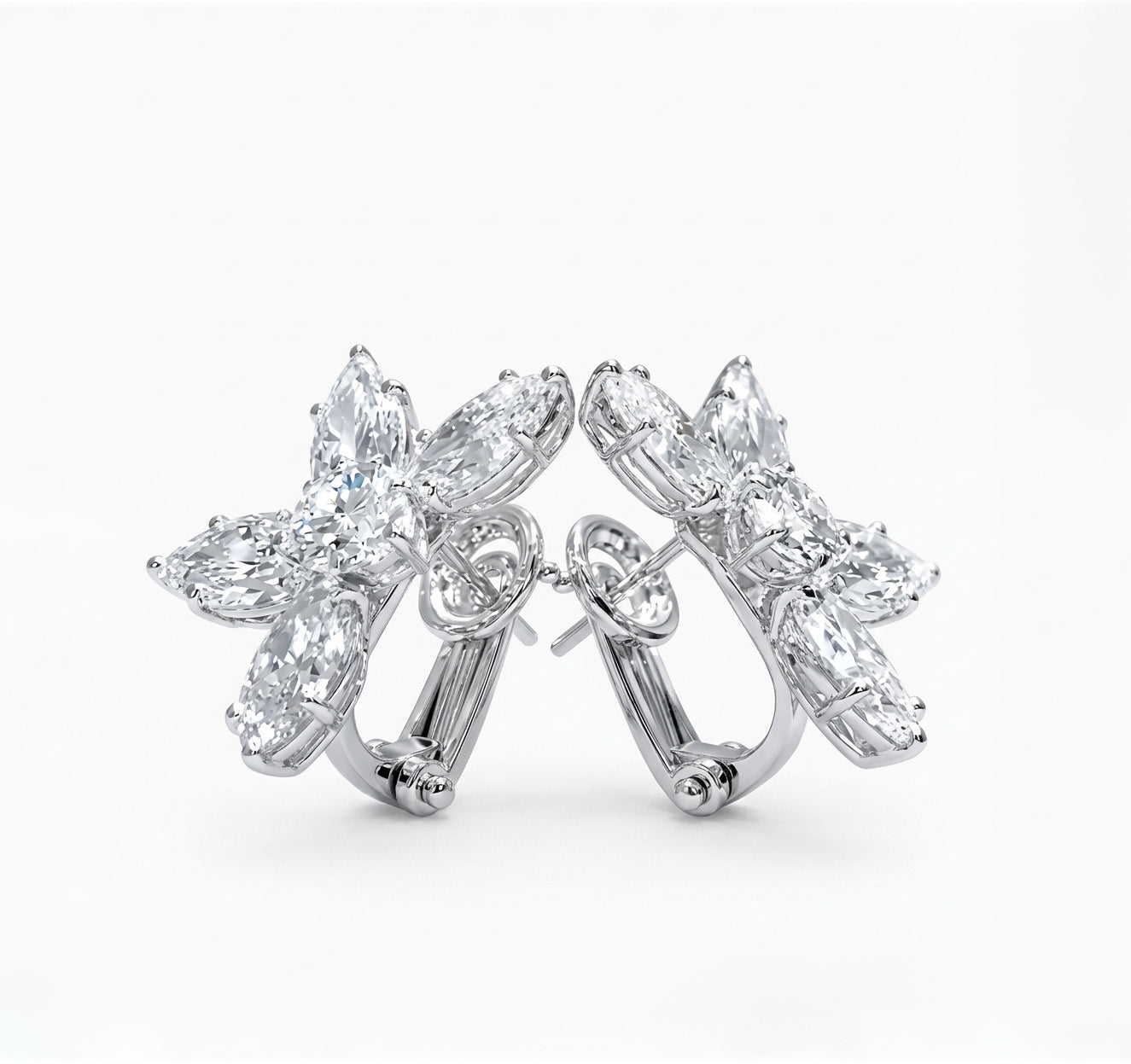 Pair of floral white diamond earrings on a white background