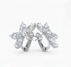 Pair of floral white diamond earrings on a white background
