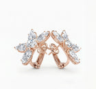 side view of rose gold earrings with diamonds on a white background