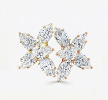 Pair of floral diamond earrings on a white background