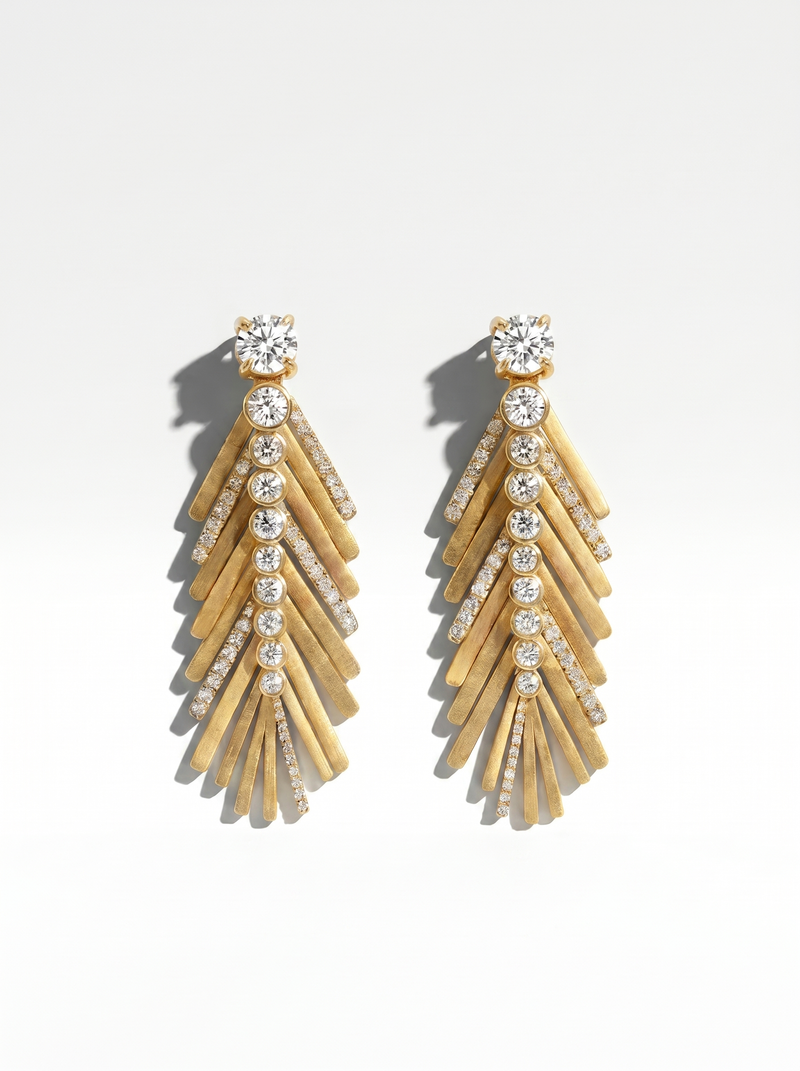 Gold and diamond earrings in the shape of a palm tree on a white background